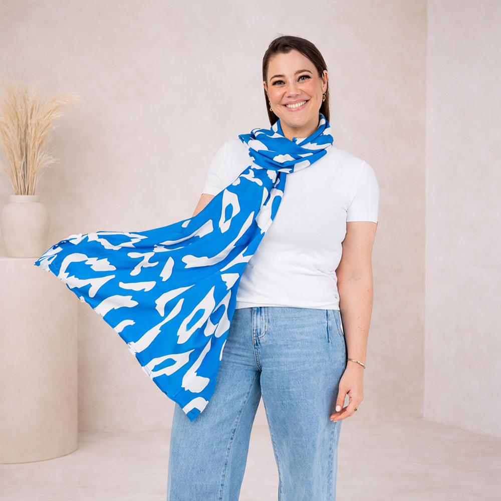Woman wearing a blue and white patterned scarf in a neutral setting