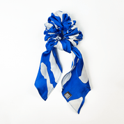 Blue Rimba batik scrunchie with ribbon tail on white background.