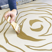 an artisan in the process of waxing in batik using a brush