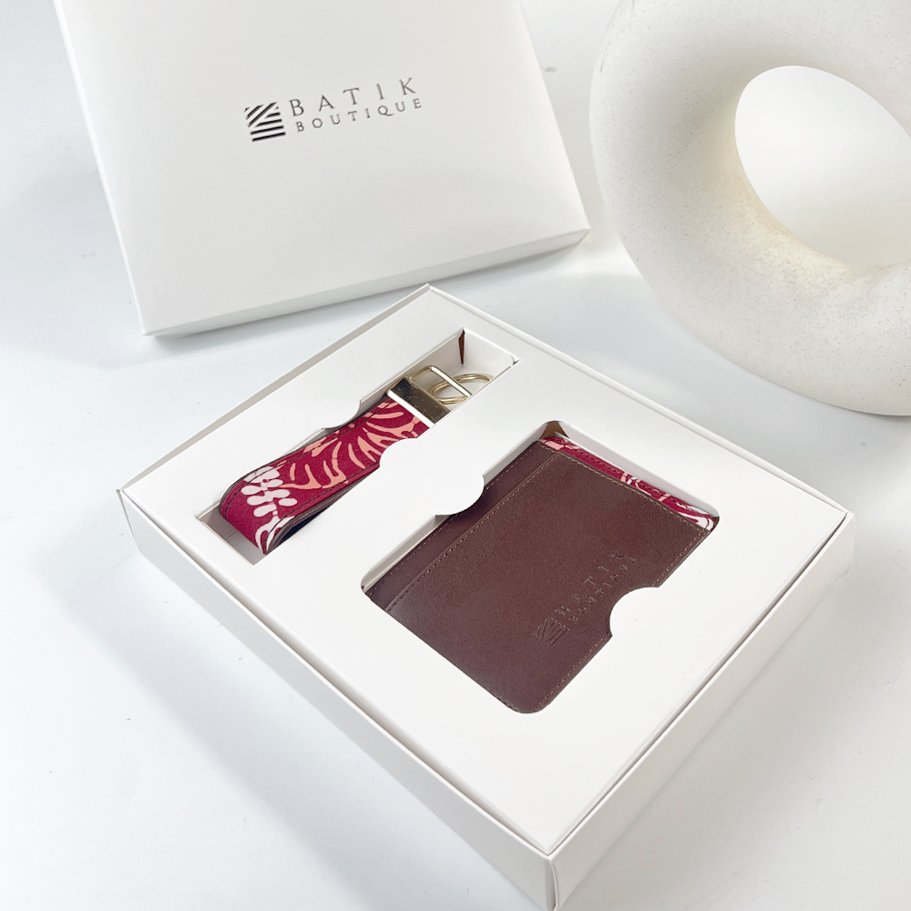 Brown leather cardholder with red pattern in a white box, branded 'Batik Boutique'.