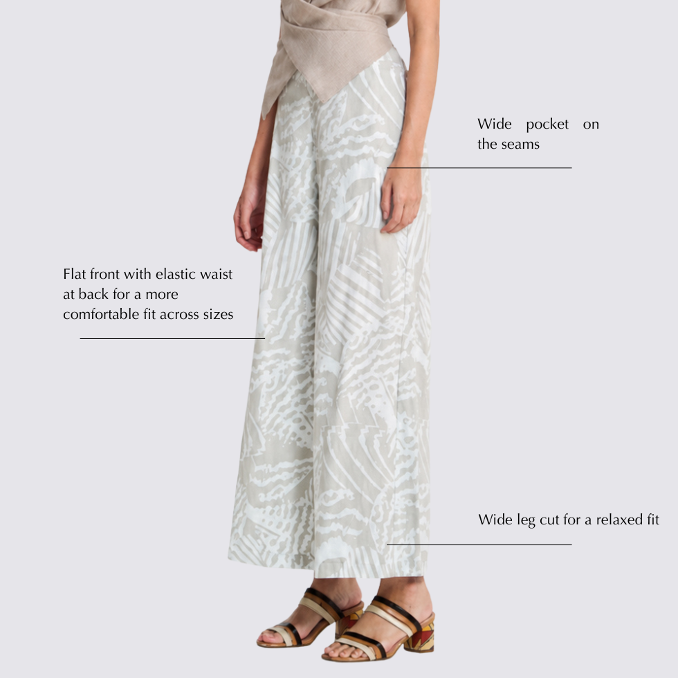 Woman wearing grey printed batik wide leg trousers with labelled features by the side