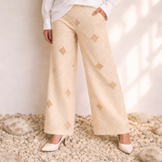 Beige patterned pants worn by a person standing on a rocky surface with a neutral background