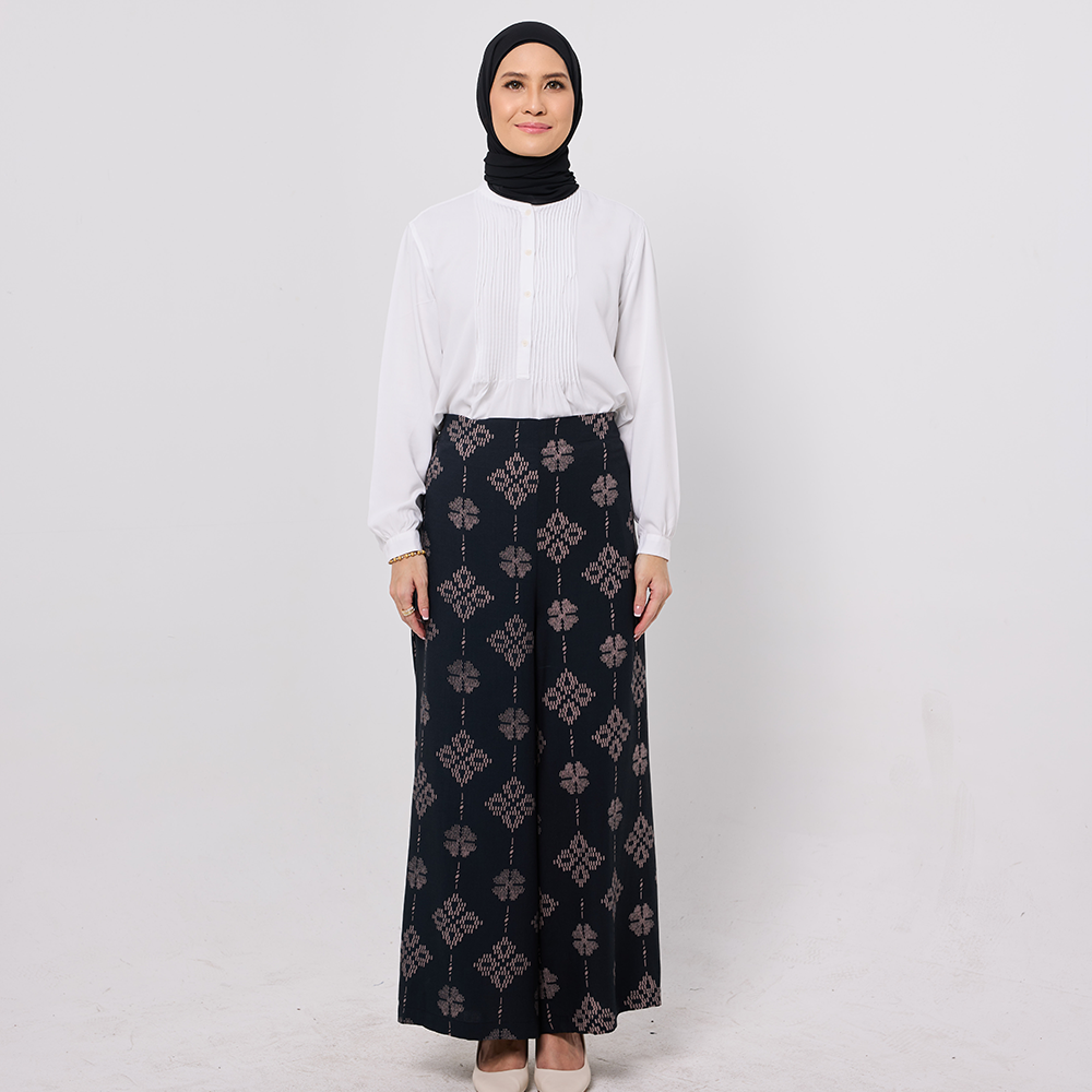 Woman wearing a white blouse and black patterned skirt on a white background