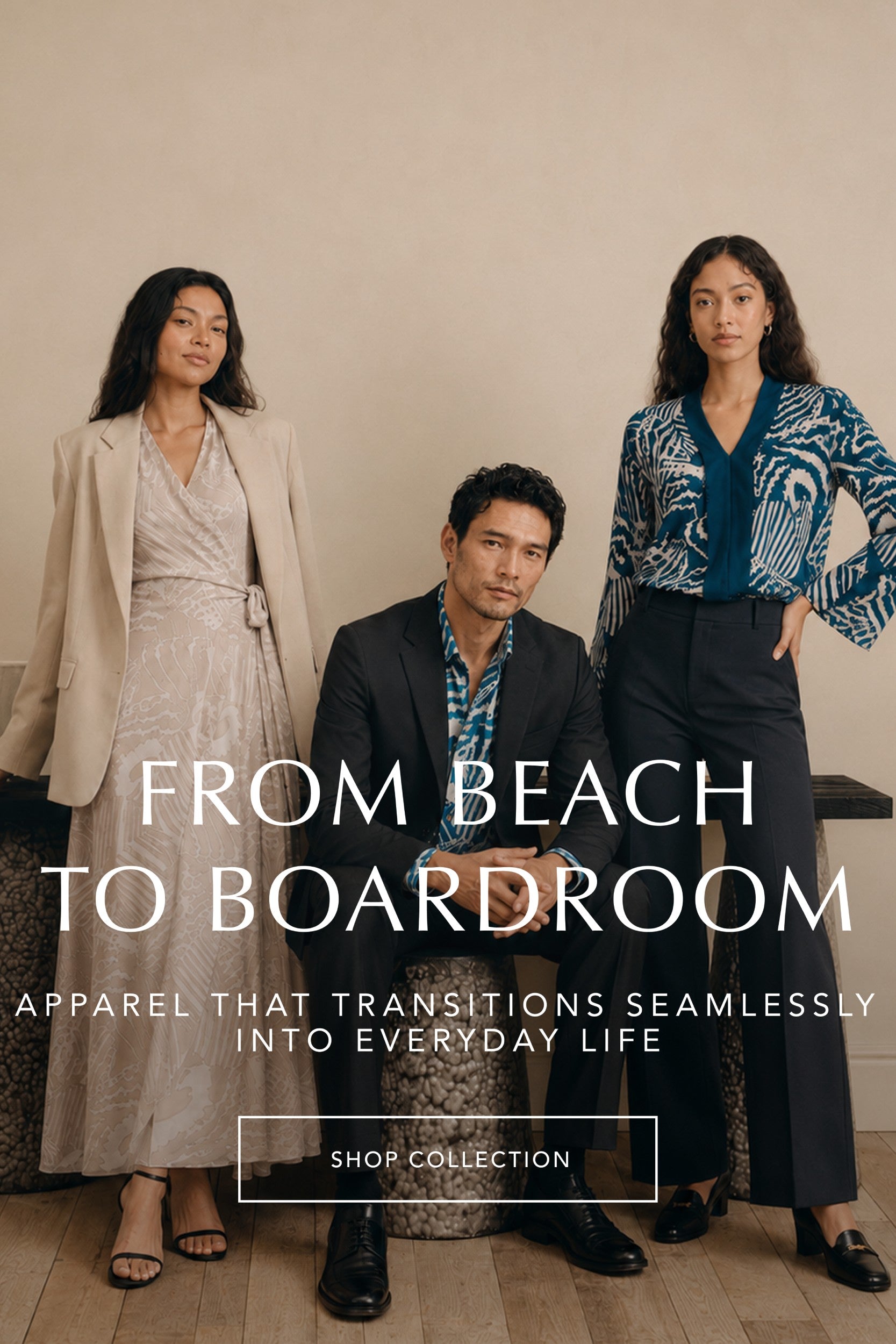 Three models pose in stylish apparel in a warm indoor setting. A woman on the left wears a beige blazer over a light dress, a man in the center wears a dark blazer over a blue patterned shirt, and a woman on the right wears a blue and white patterned blouse with dark trousers.