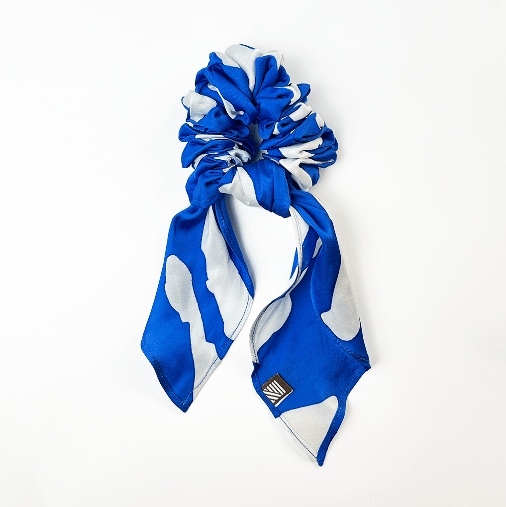 Blue Rimba batik scrunchie with ribbon tail on white background.