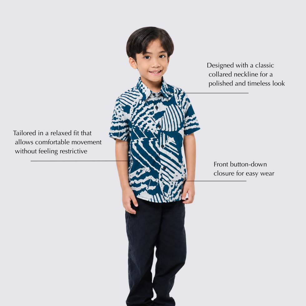 A child model wearing a short-sleeve button-down shirt with a blue and white abstract pattern, shown against a light gray background with text callouts describing the shirt's fit, collar design, and front closure.