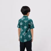 Child wearing a green patterned shirt on a white background
