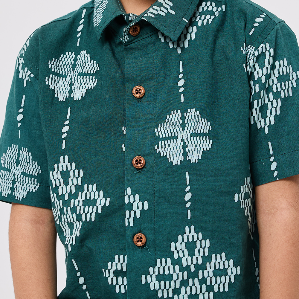 Green shirt with white geometric patterns worn by a person
