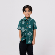 Child wearing a green patterned shirt on a white background