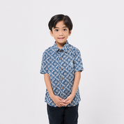 Child wearing a blue patterned shirt on a white background