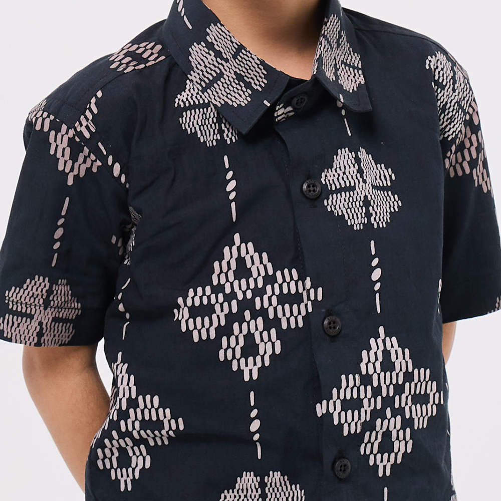 Black shirt with white geometric pattern on a plain background