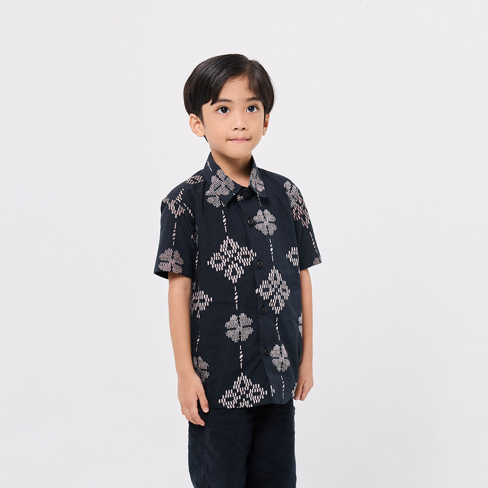 Child wearing a dark patterned shirt on a white background