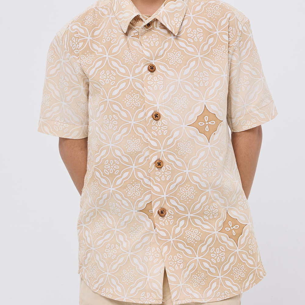 Beige patterned shirt worn by a person on a white background