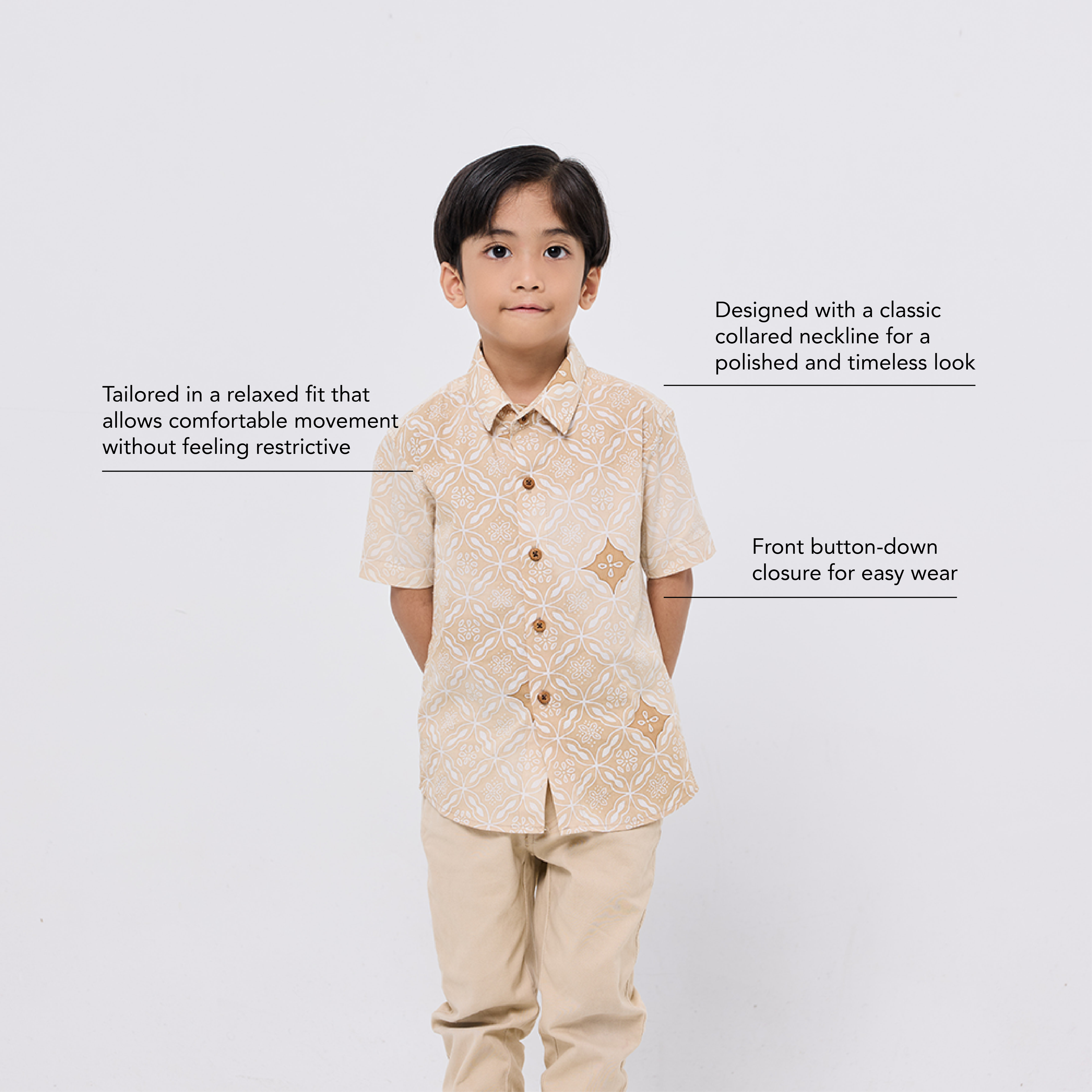 Child wearing a beige patterned shirt and pants on a white background
