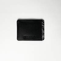 A whitebox photo of card case in genuine black leather with a touch of batik fabric at the side in black driftwood pattern. Batik Boutique logo is engrave at the bottom
