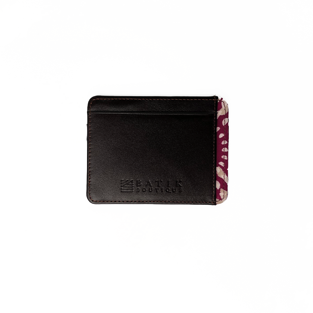 A whitebox photo of card case in genuine dark brown leather with a touch of batik fabric at the side in crimson lunar pattern. With Batik Boutique logo engraved