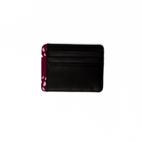A whitebox photo of card case in genuine black leather with a touch of batik fabric at the side in crimson lunar pattern