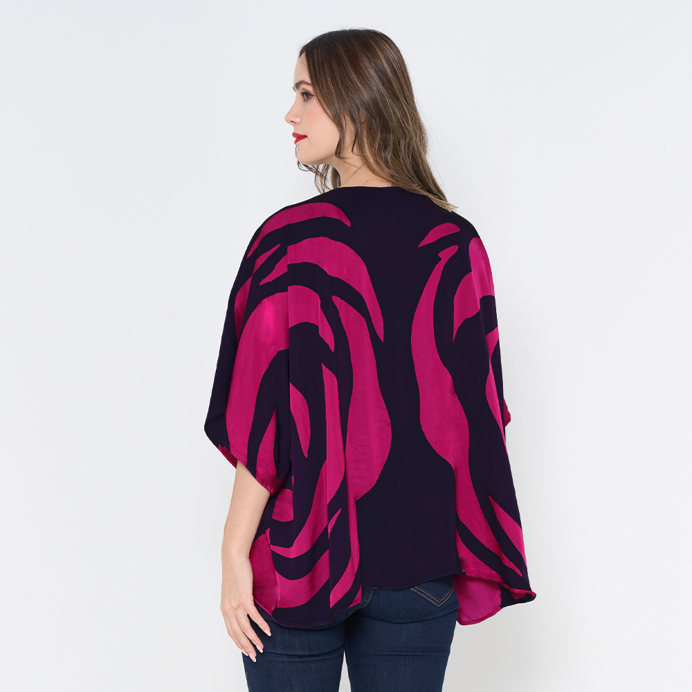 a female model posing with her back to the camera against a white background to showcase the batik kimono in the pattern fuchsia rose