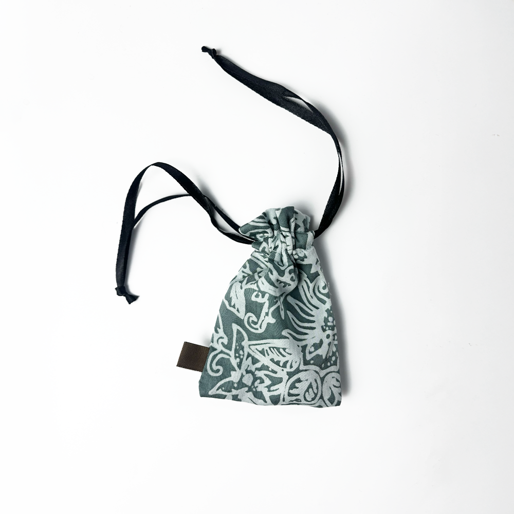 Sage green batik drawstring pouch with white floral motif, handmade by Batik Boutique artisans using traditional batik techniques.