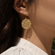 Closeup of gold earring that resembles a hyrangea flower