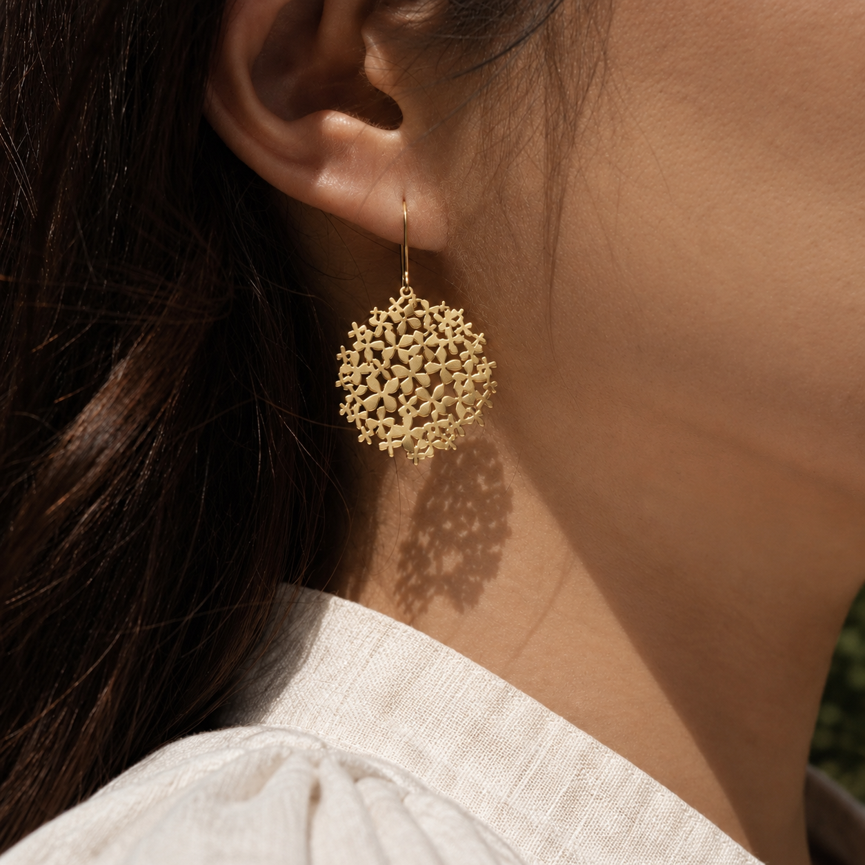 Closeup of gold earring that resembles a hyrangea flower