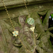 Necklace with floral and circular pendants on a wooden surface