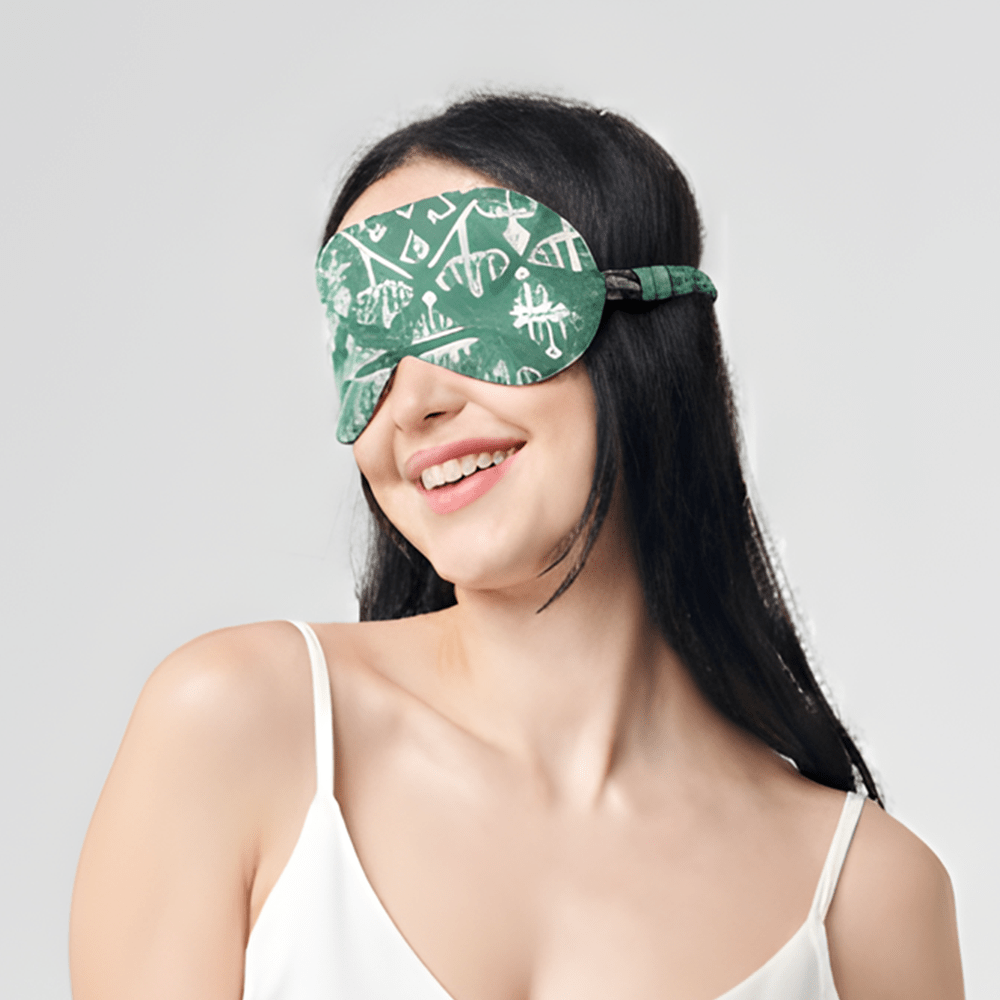 Woman wearing Batik Boutique turquoise batik eye mask with geometric tikar motif, smiling in white camisole against neutral background.