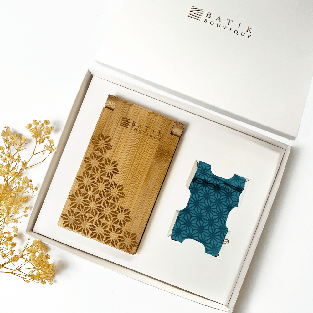 a whitebox photo of congkak against a white background with laser engraved congkak board and batik pouch of forest firework