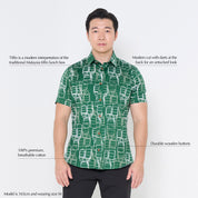 a male model posing in a batik shirt against a white background in green tiffin