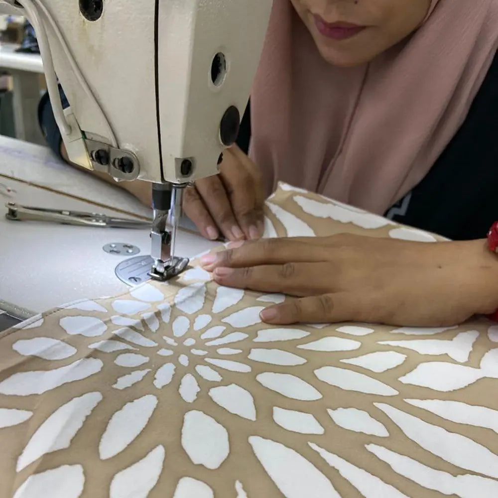 an artisan showing to be sewing batik 