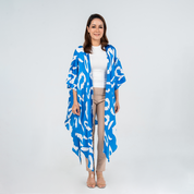 Woman wearing Batik Boutique’s Blue Rimba kimono with bold hand-drawn batik patterns in blue and white, styled over a white top and beige pants