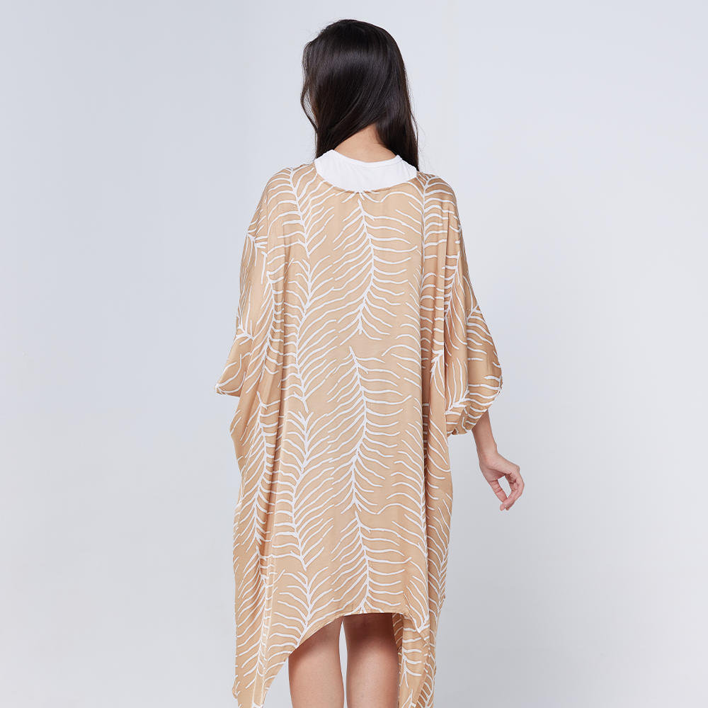 a female model showcasing a batik kimono against a white background in the pattern latte fern