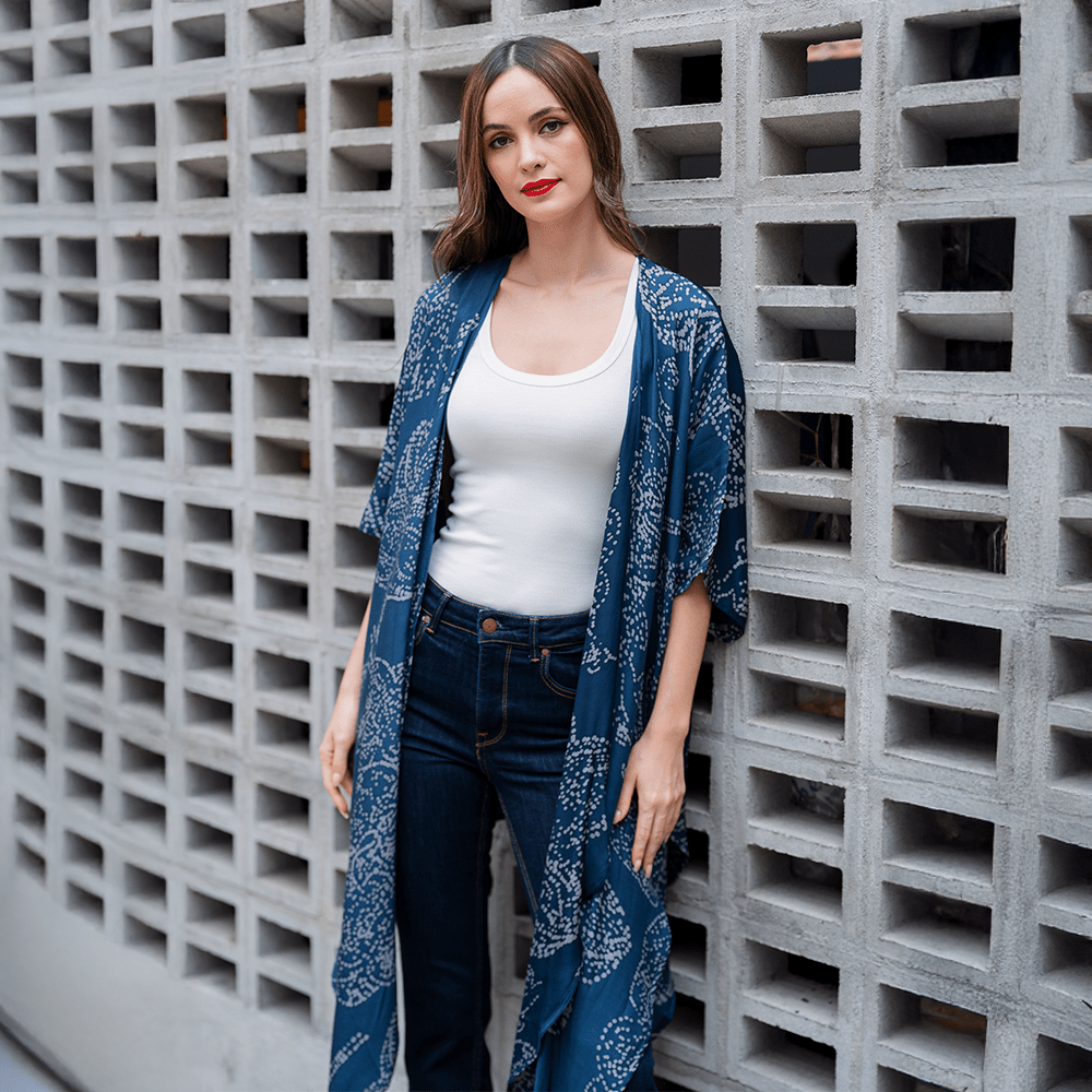 a woman posing in front of a concrete wall in a batik kimono navy orchid