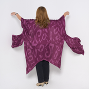 a woman posing in a batik kimono against a white background