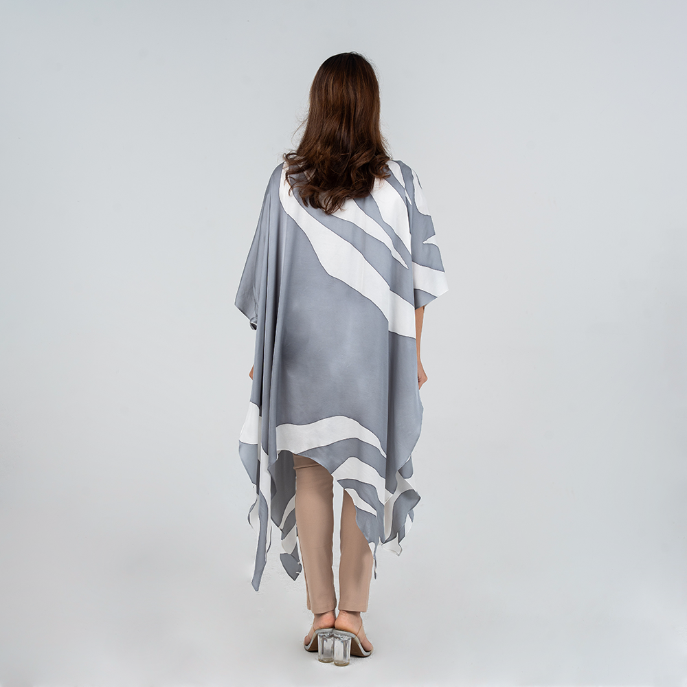 Woman wearing Batik Boutique’s Silver Rose kimono showing back view, featuring hand-drawn floral batik in silver and white on breathable silk cotton.