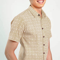 a close up of a man standing in front of a white wall in latte kompas batik shirt from batik boutique