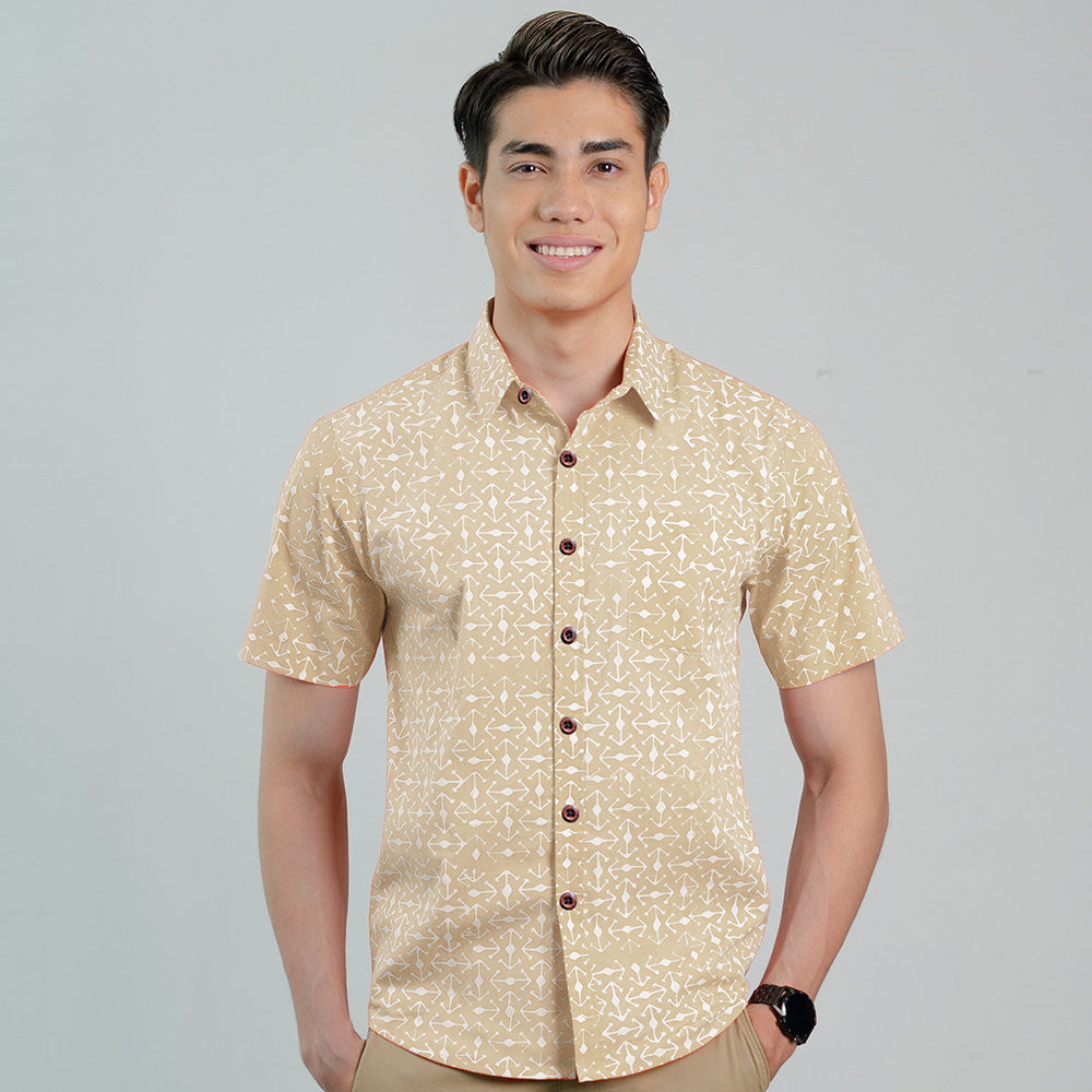 a man standing in front of a white wall in latte kompas batik shirt from batik boutique