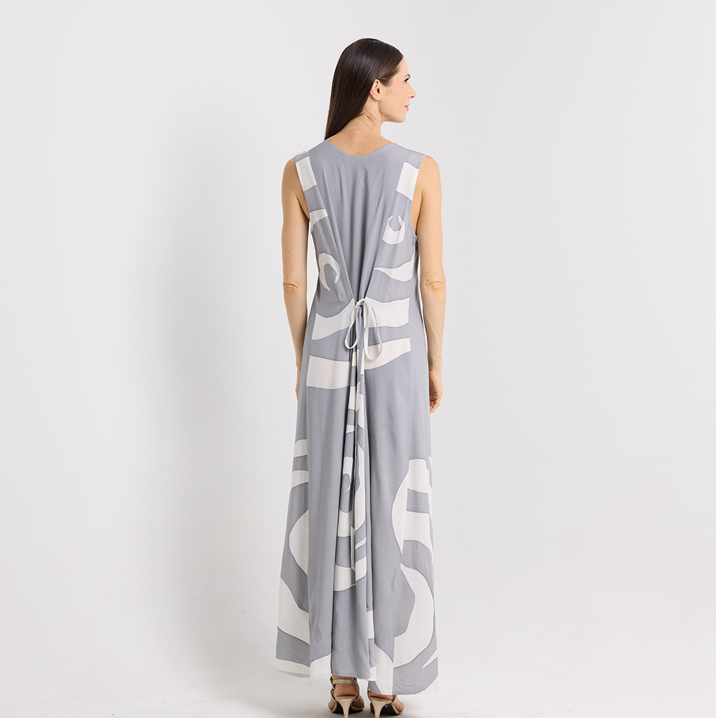 Woman wearing a gray sleeveless dress with white abstract patterns on a white background