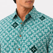 Man wearing a green patterned shirt with white floral design