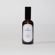 A bottle of Linen Mist - Citrus Spice (Mangosteen) room spray with a white label on a white background.