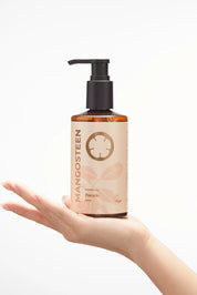 Hand holding a bottle of Mangosteen product with a white background