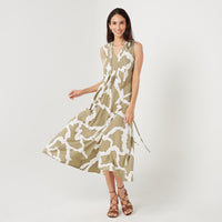 a woman standing in front of white background styling batik long maxi dress in stone chain pattern