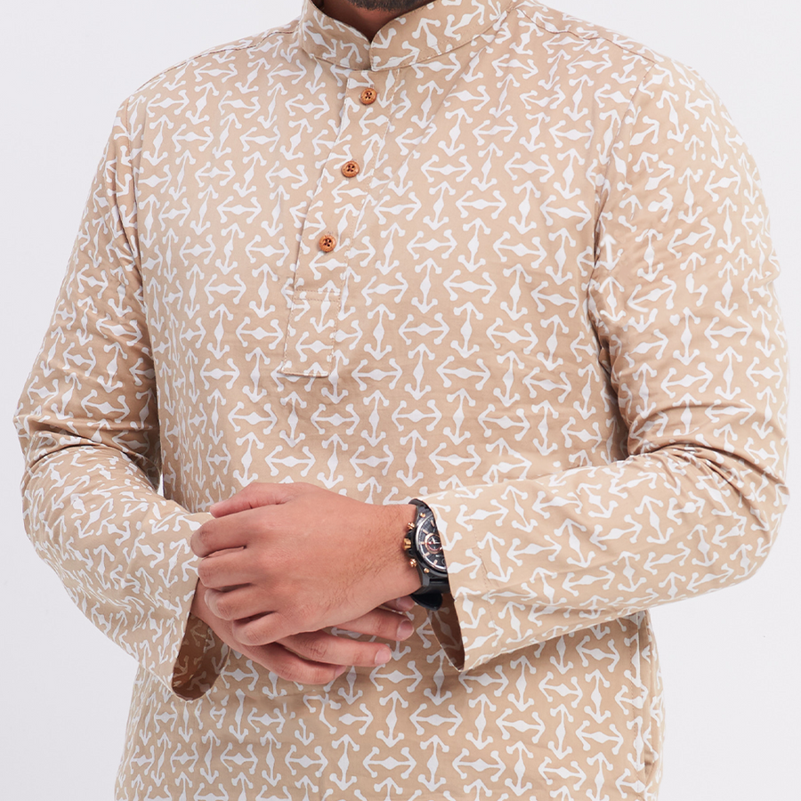 A close up photo of a male model with his hands in his pockets of the batik kurta in the pattern latte kompas