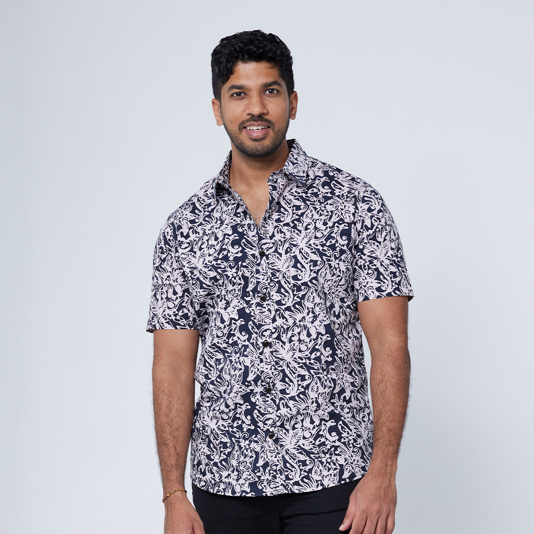 a man posing against a neutral background in an authentic malaysian batik in the pattern black floret