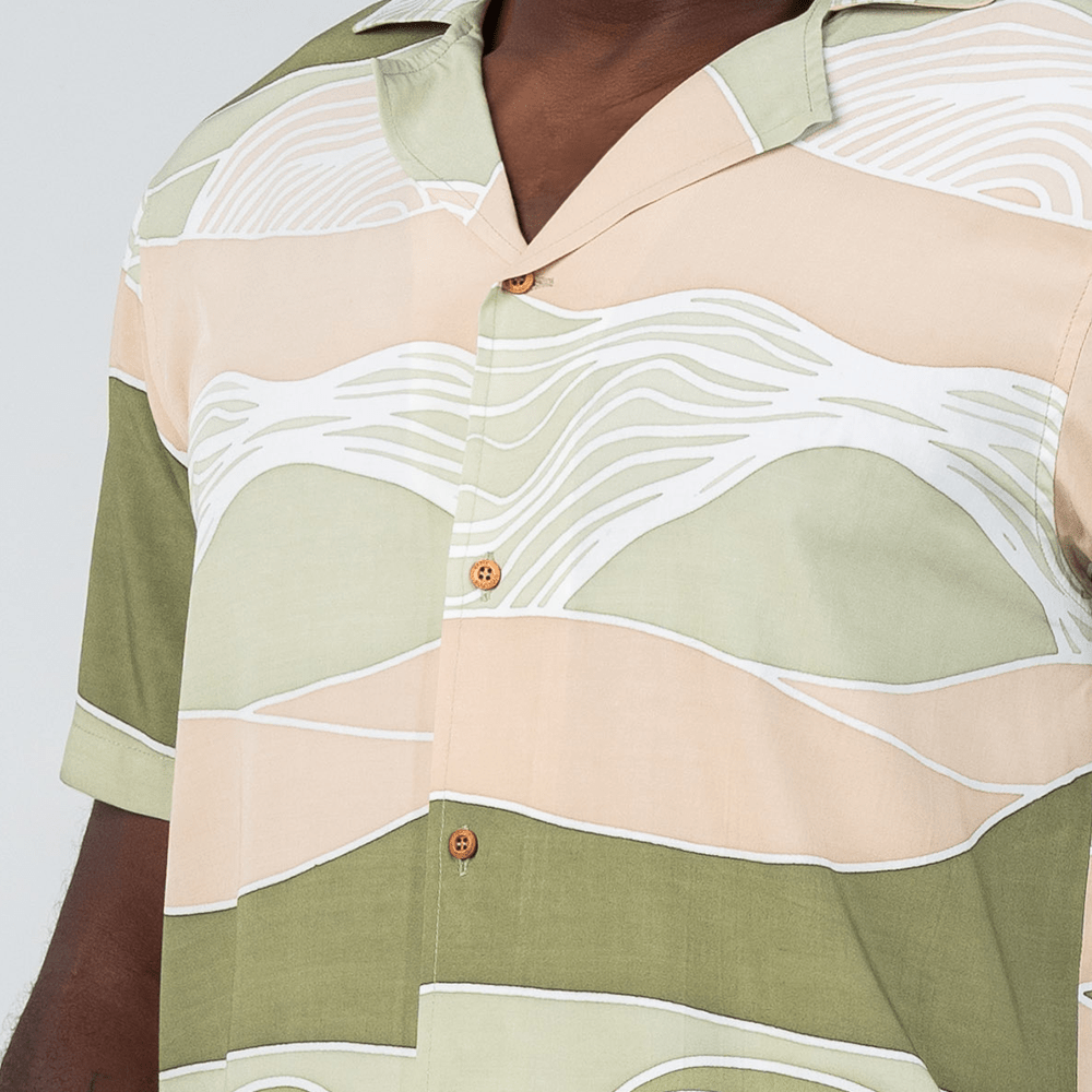 Closeup of Moss Bukit batik shirt detailing the wave-like lines and earthy green tones, showcasing wooden buttons and premium cotton craftsmanship