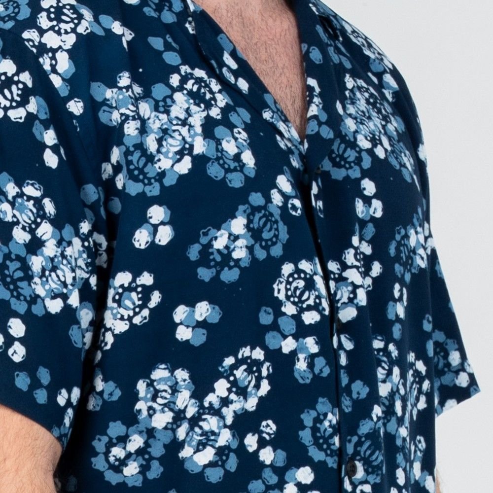 Closeup detail of the Navy Blossom batik motif on a Men’s Cuban Shirt, showcasing layered hand-painted petals in light blue, white, and navy.