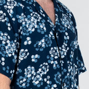 Closeup detail of the Navy Blossom batik motif on a Men’s Cuban Shirt, showcasing layered hand-painted petals in light blue, white, and navy.