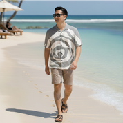 man waking on sandy beach with a silver rose batik boutique shirt