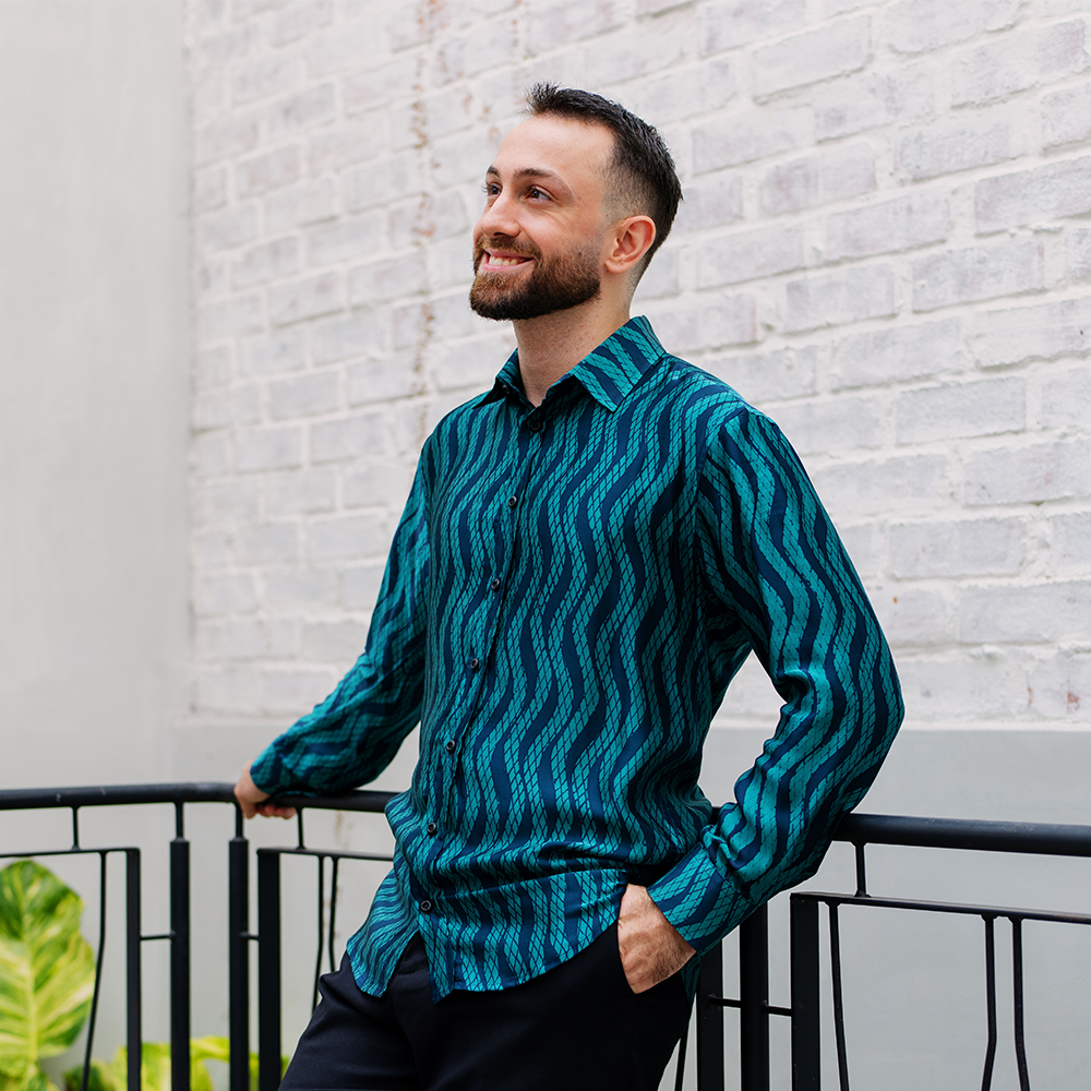 Man wearing teal Snakeskin long-sleeved batik shirt in an urban setting, styled for a smart casual look