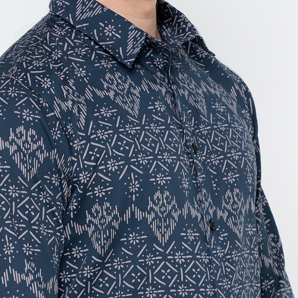 a closeup of a batik shirt in the pattern navy anyam against a white background